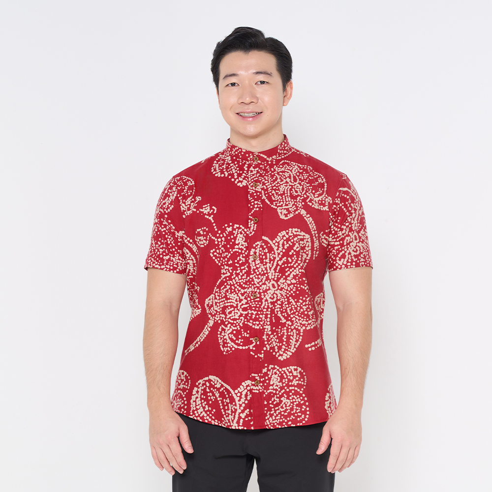 a man wearing a batik shirt with mandarin collar in the pattern crimson orchid