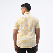 a man showcasing  details at the back of batik shirt in the pattern mustard arabesque