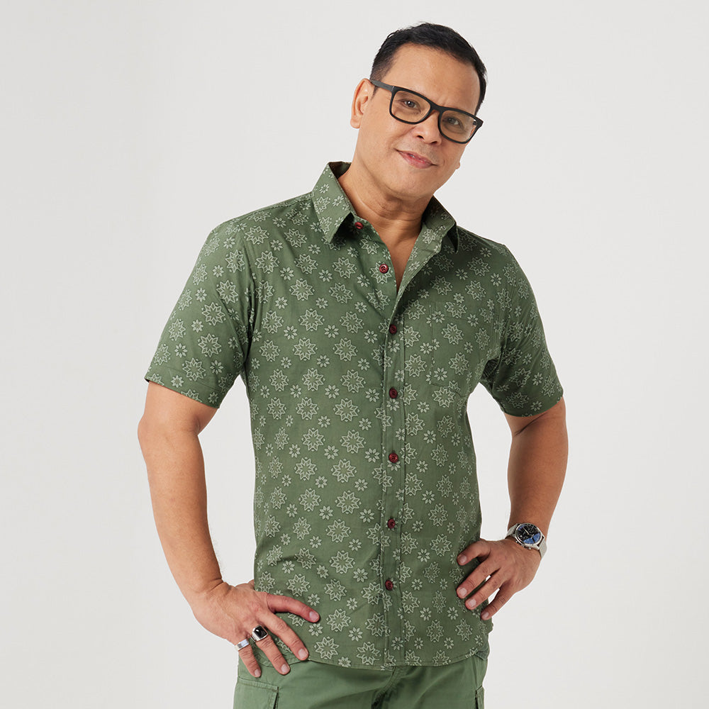  a man standing in front of white background styling batik short sleeved in olive Bintang pattern