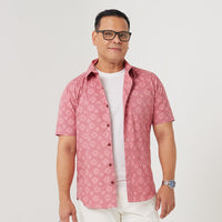  a man standing in front of white background styling batik short sleeved in pink Bintang pattern