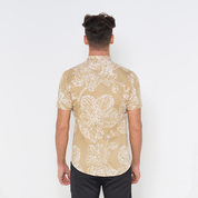 a man wearing a batik shirt against a white background in the pattern tan orchid showcasing the details on the back