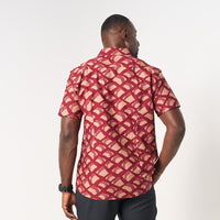 A man is wearing red color batik short sleeve shirt in Nasi Lemak, a renowned cultural dish in Malaysia. Batik shirt is made in cotton material, using technique of traditional batik technique 
