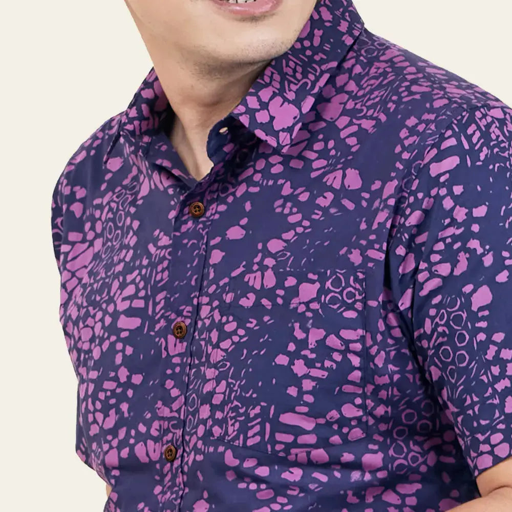 A close-up photograph highlighting the intricate Purple Bintik batik pattern against a neutral backdrop
