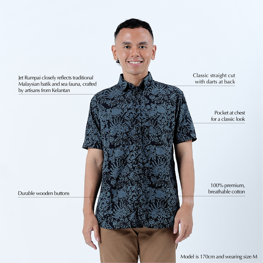 a man posing in front of a white background in a batik shirt in the pattern jet rumpai with the product features