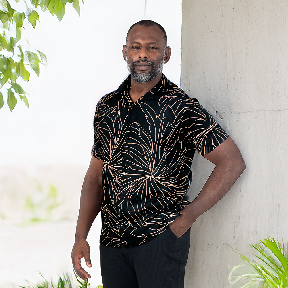 Man wearing Onyx Palma batik Cuban shirt in outdoor lifestyle setting.