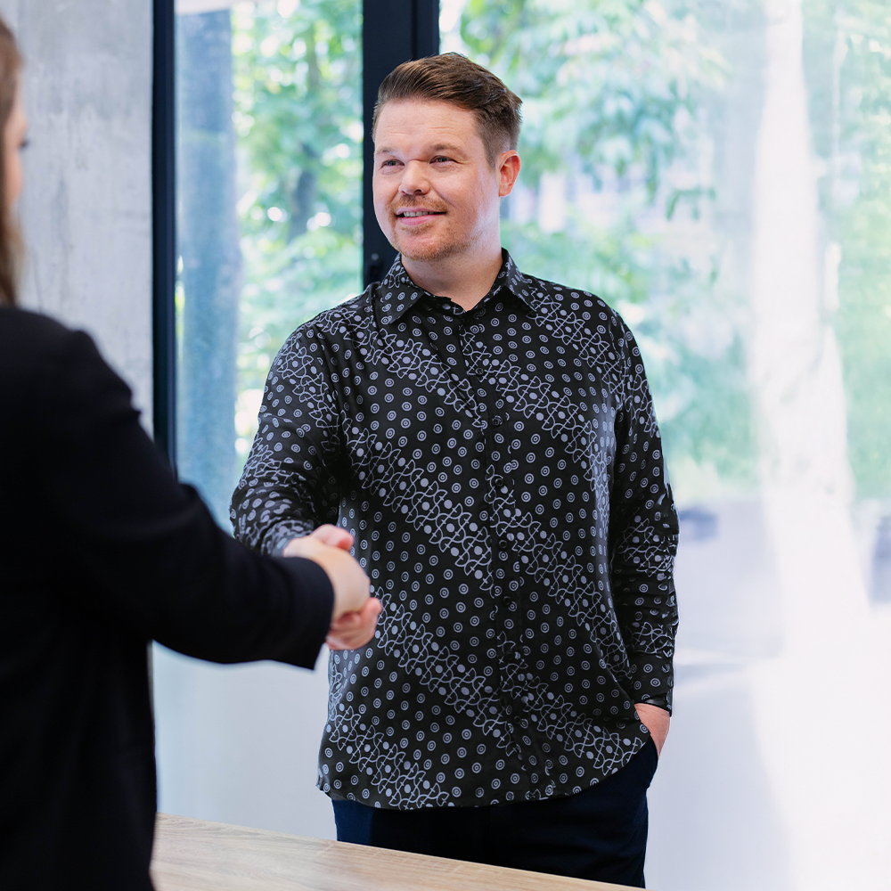 Man wearing Jet Alur batik shirt in office setting, styled for formal or business casual wear.