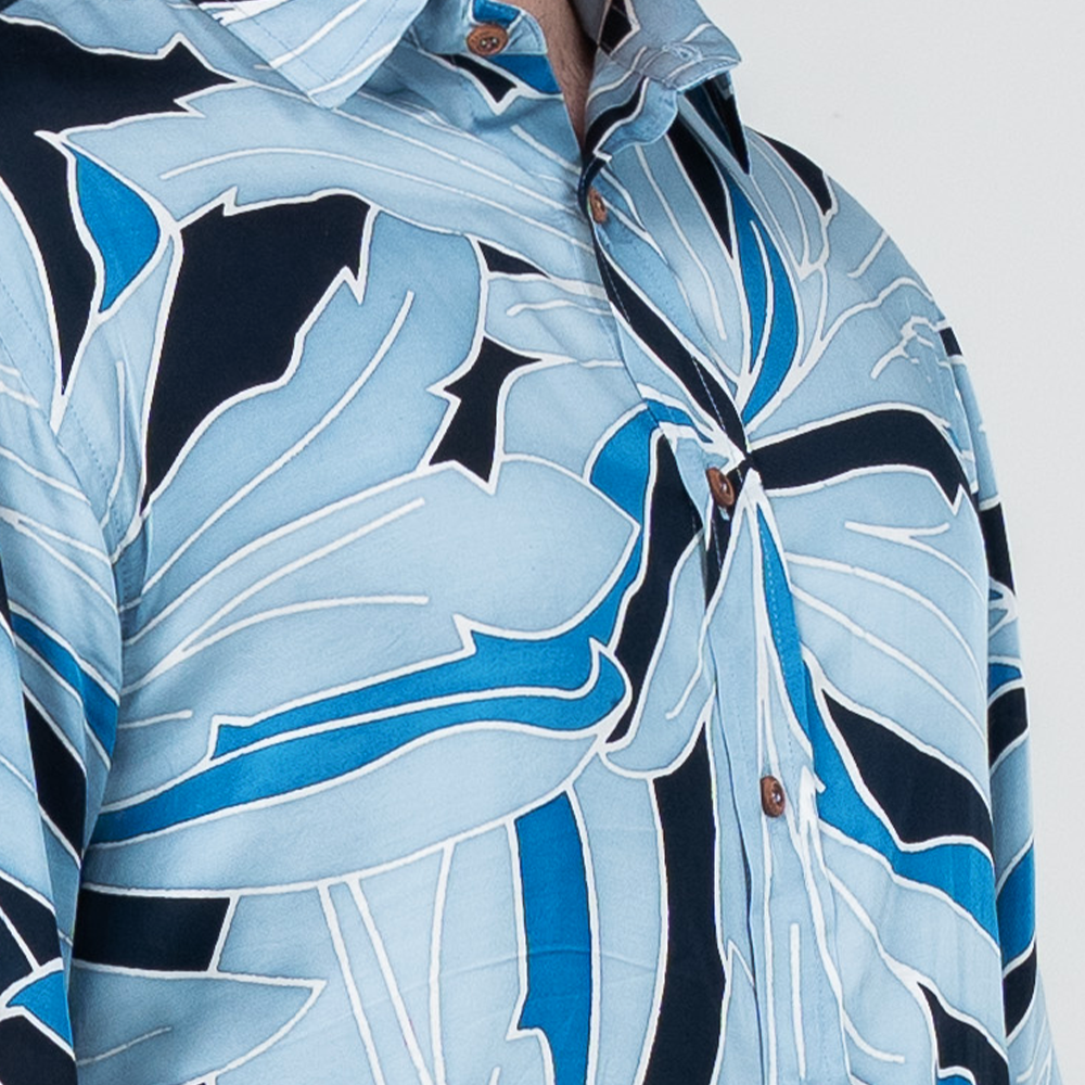 Close-up of moonlight Palma batik shirt showing hand-drawn tropical leaf details and natural wooden buttons