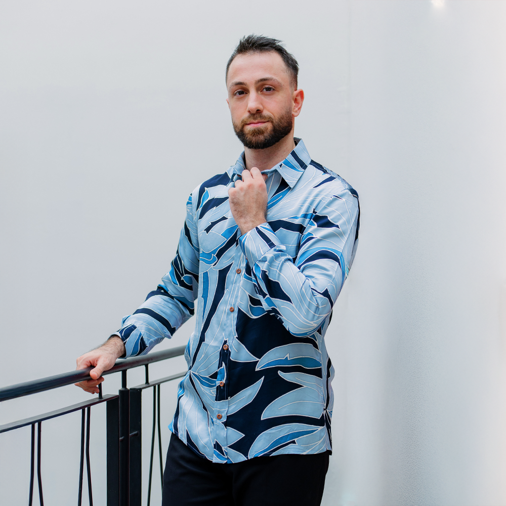 Man wearing moonlight blue Palma batik shirt styled outdoors, showcasing a modern tropical look