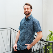 Man wearing the Navy Driftwood batik shirt, smiling in an outdoor setting.
