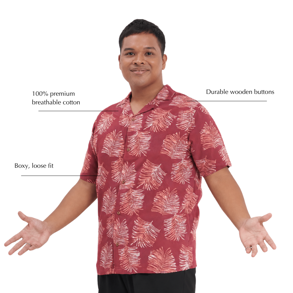 A man wearing a short-sleeve button-up shirt with a red and white palm leaf pattern, shown against a plain white background with text callouts describing the shirt's features.