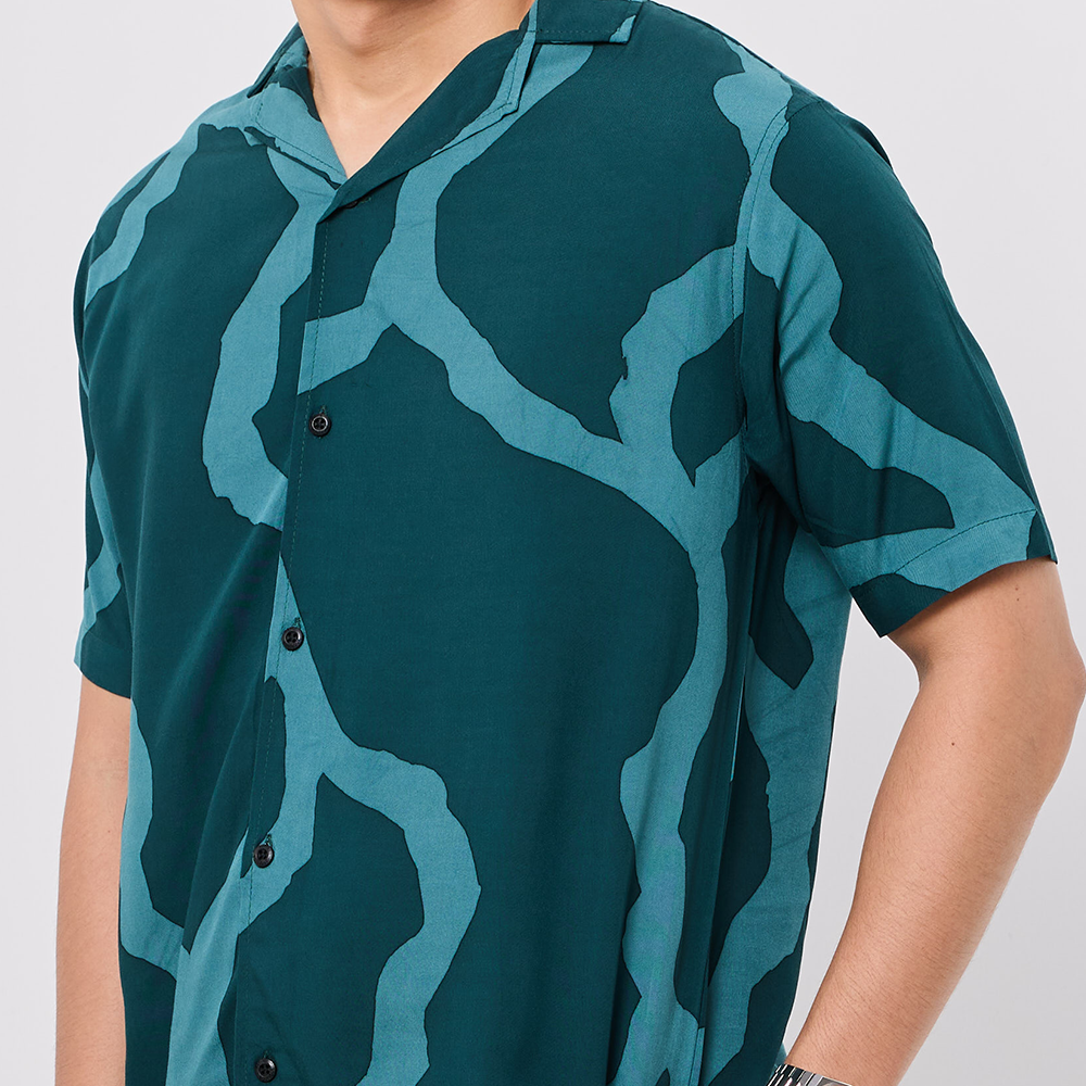 Person wearing a green camouflage patterned shirt on a white background