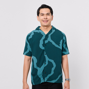 Man wearing a green patterned shirt on a white background