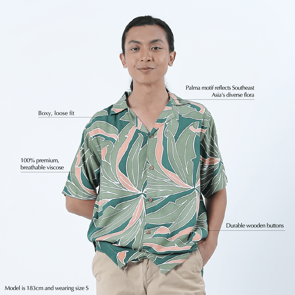 Man wearing a green and pink leaf pattern shirt on a white background