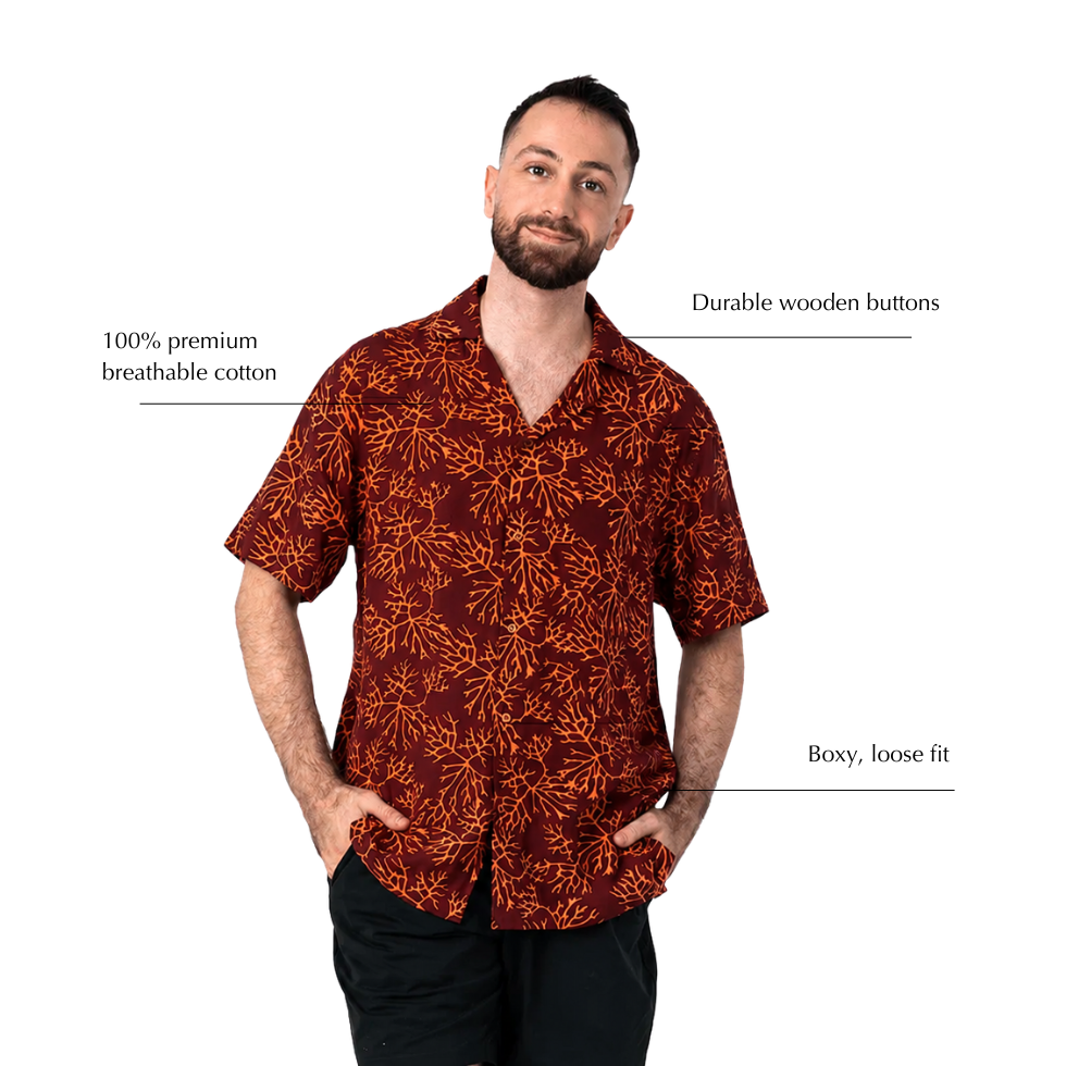 A man modeling a short-sleeve button-up shirt with a rust-orange abstract leaf pattern on a dark red background, with text callouts highlighting features like breathable cotton, wooden buttons, and a loose fit.