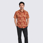 Man wearing orange printed batik shirt facing the front