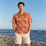 Man wearing orange printed batik shirt outside