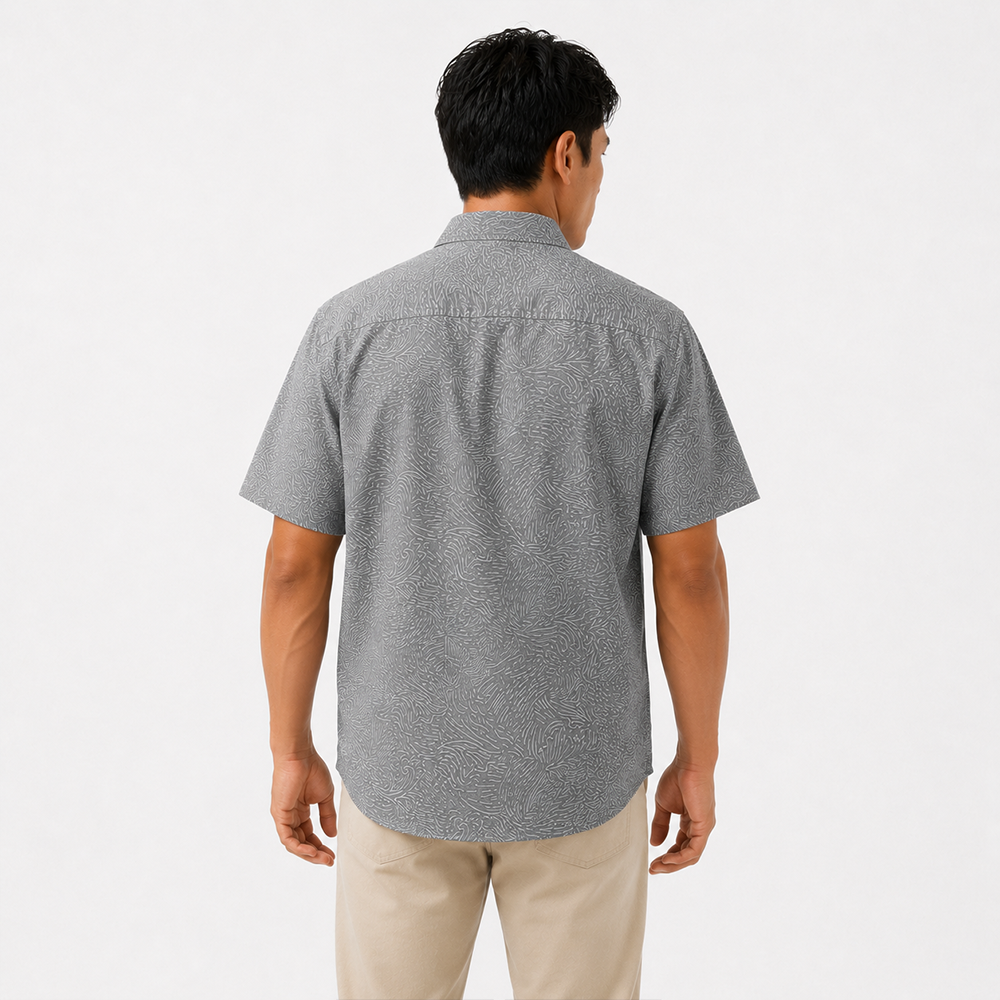 Man wearing a gray patterned short-sleeve shirt on a white background