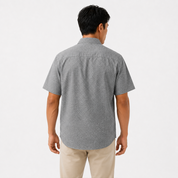 Man wearing a gray patterned short-sleeve shirt on a white background