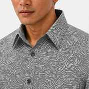 Man wearing a gray patterned shirt with a close-up of the collar.
