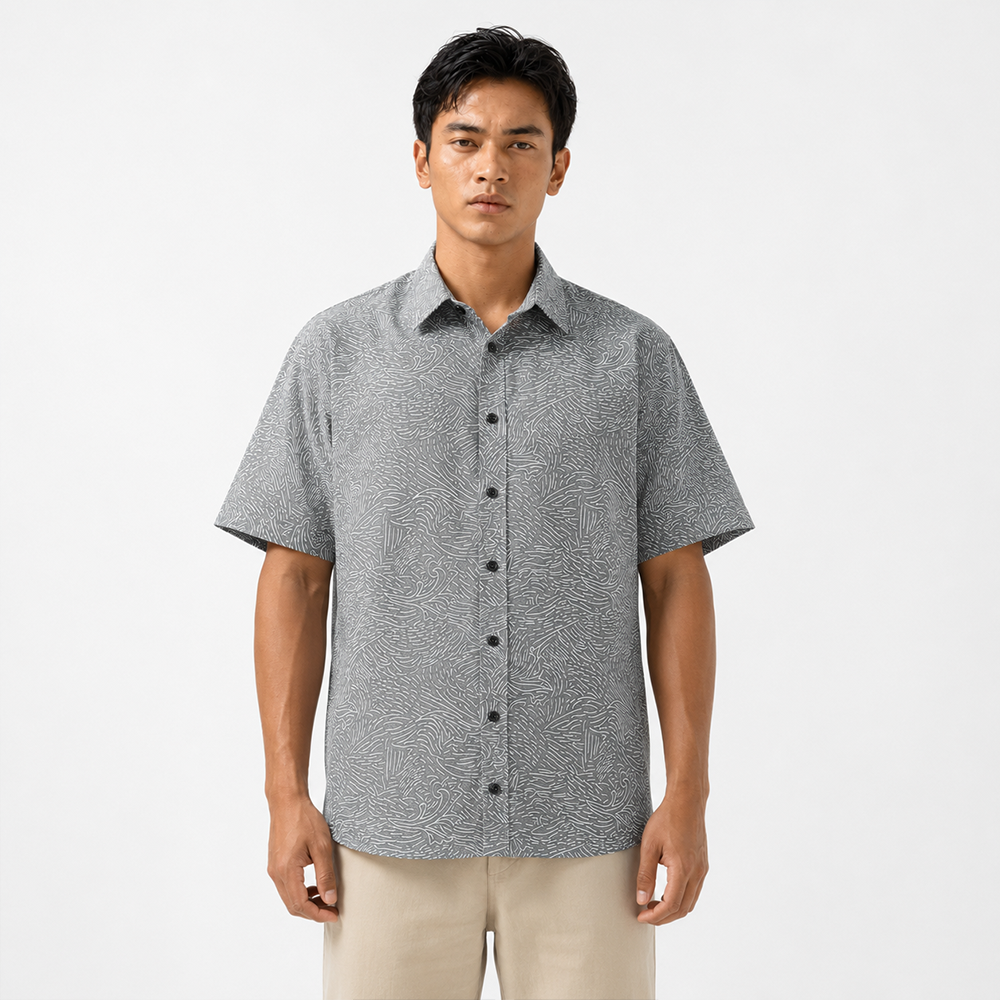 Man wearing a patterned short-sleeve shirt on a white background
