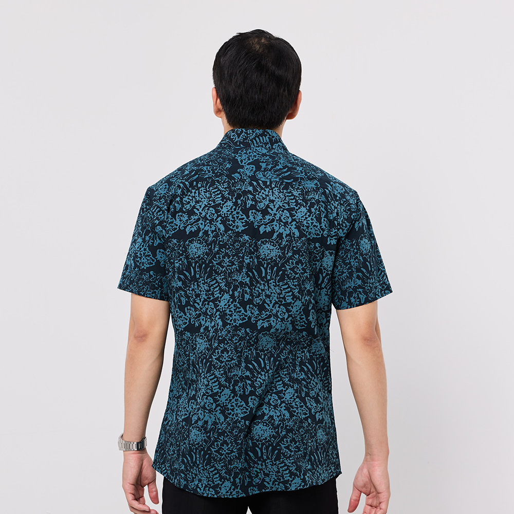 Person wearing a blue patterned shirt on a white background