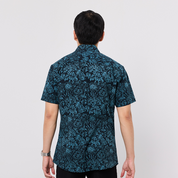 Person wearing a blue patterned shirt on a white background