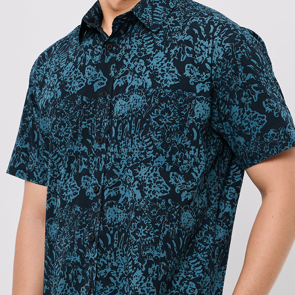 Person wearing a blue patterned shirt on a white background