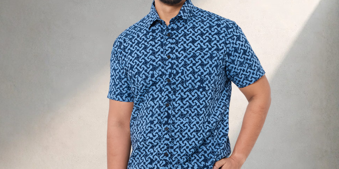 Man wearing a blue patterned shirt against a neutral background