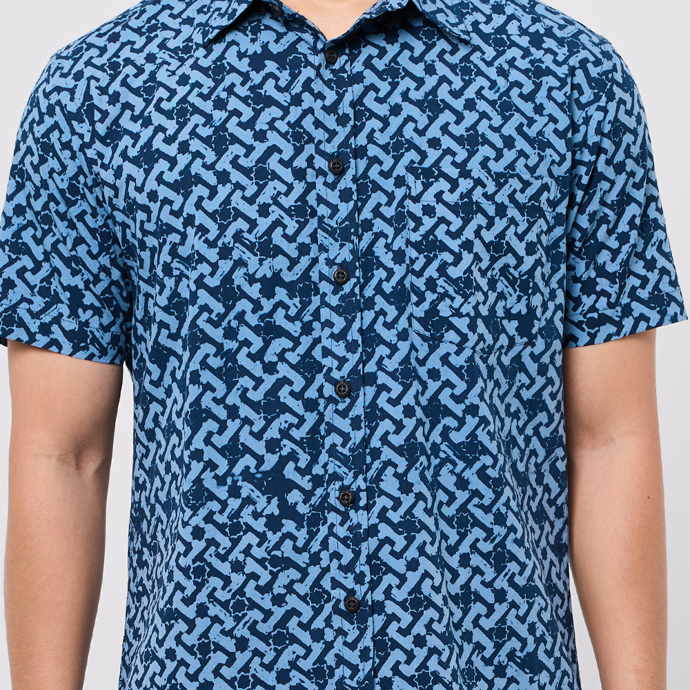 Blue patterned shirt worn by a person on a plain background