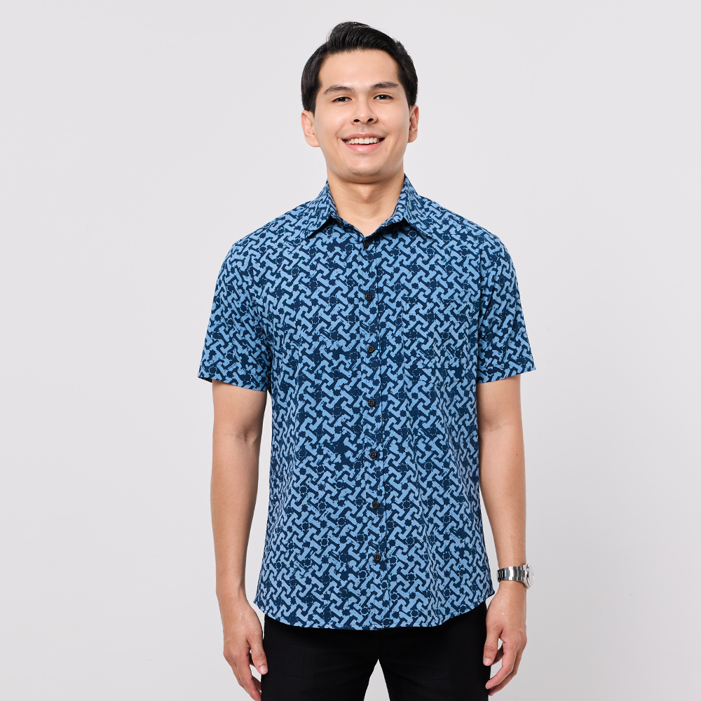 Man wearing a blue patterned shirt on a white background