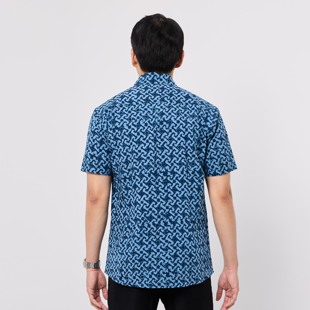 Person wearing a blue patterned shirt on a white background