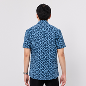 Person wearing a blue patterned shirt on a white background