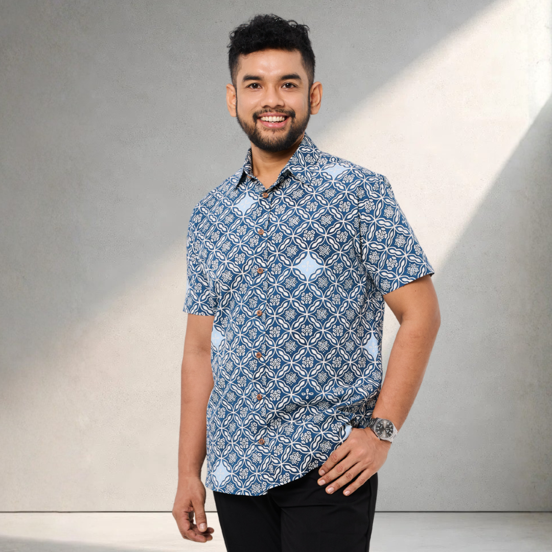 Man wearing a blue patterned shirt against a gray background