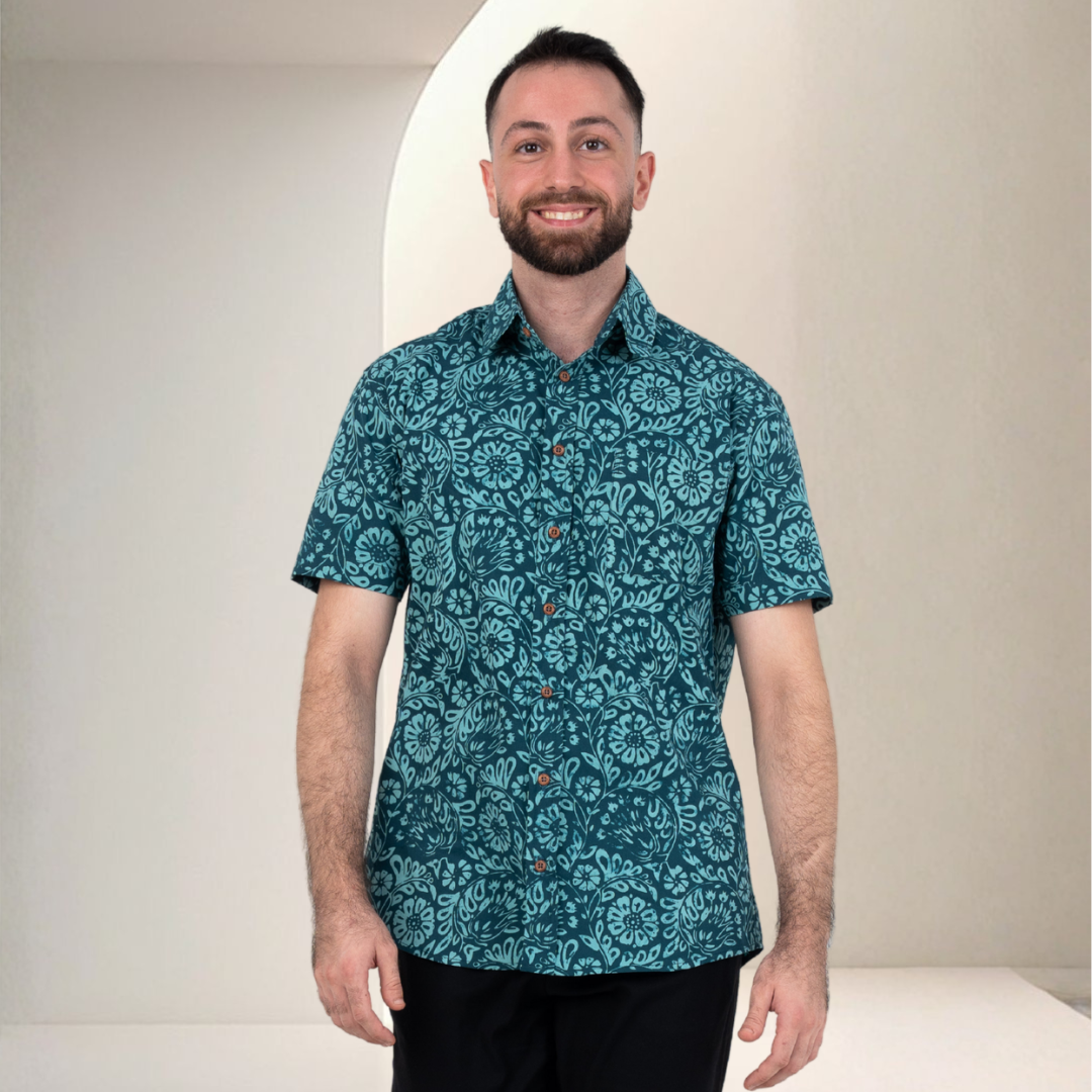 Man wearing a teal patterned Batik shirt against a plain background