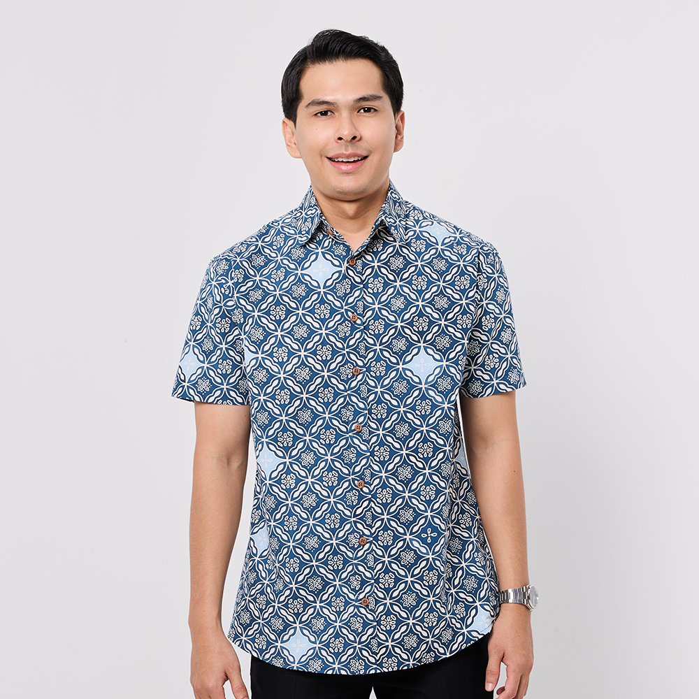 Man wearing a blue patterned shirt on a light gray background