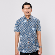 Man wearing a blue patterned shirt on a light gray background