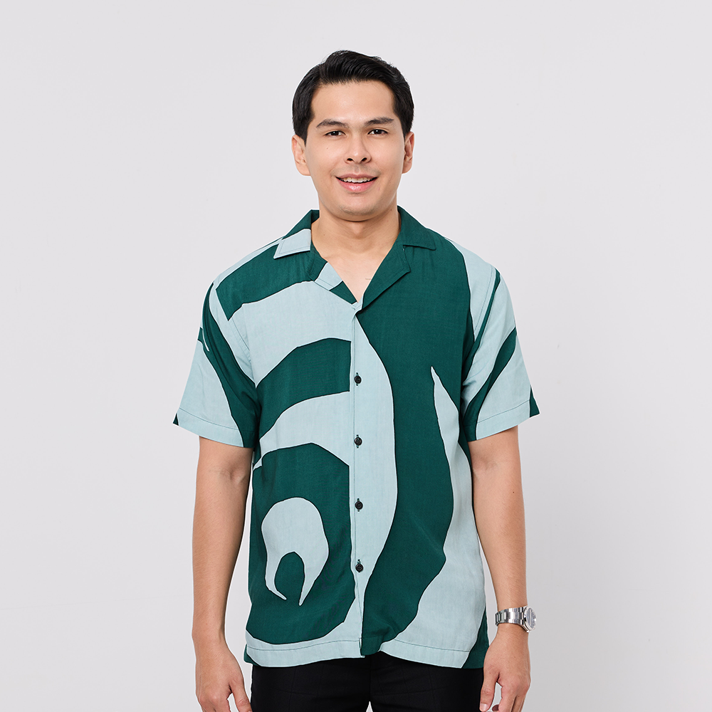 Man wearing a patterned shirt on a plain background