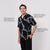 Man wearing a black and gray patterned shirt on a white background
