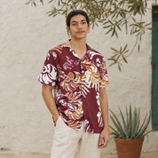 Man wearing maroon printed batik shirt posing outside