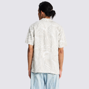 Man facing the back showing the back print of the gray batik shirt he's wearing