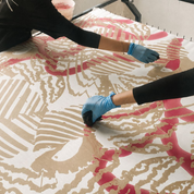 Person applying a decorative pattern to a surface with blue gloves