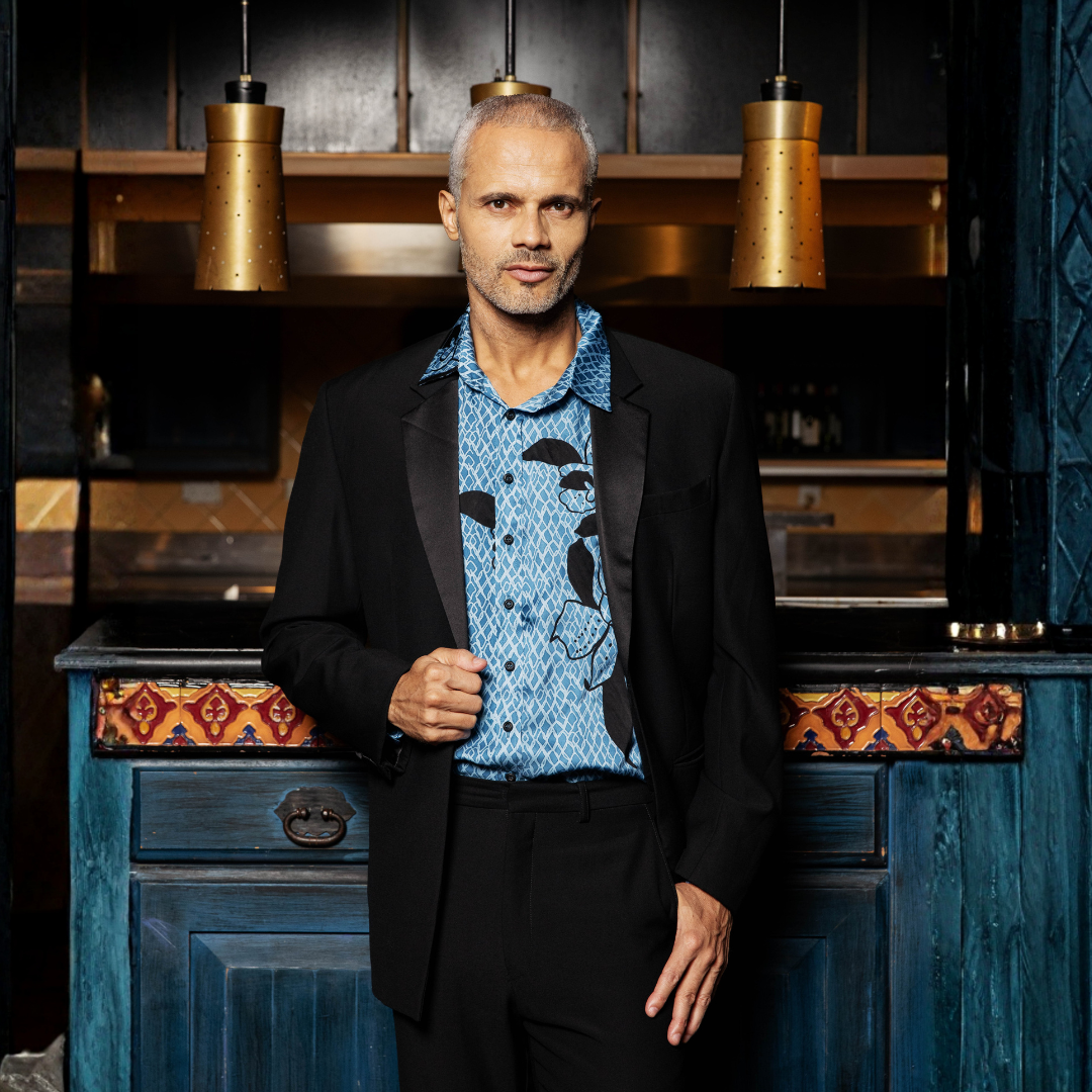 Man in a stylish outfit standing in a restaurant setting