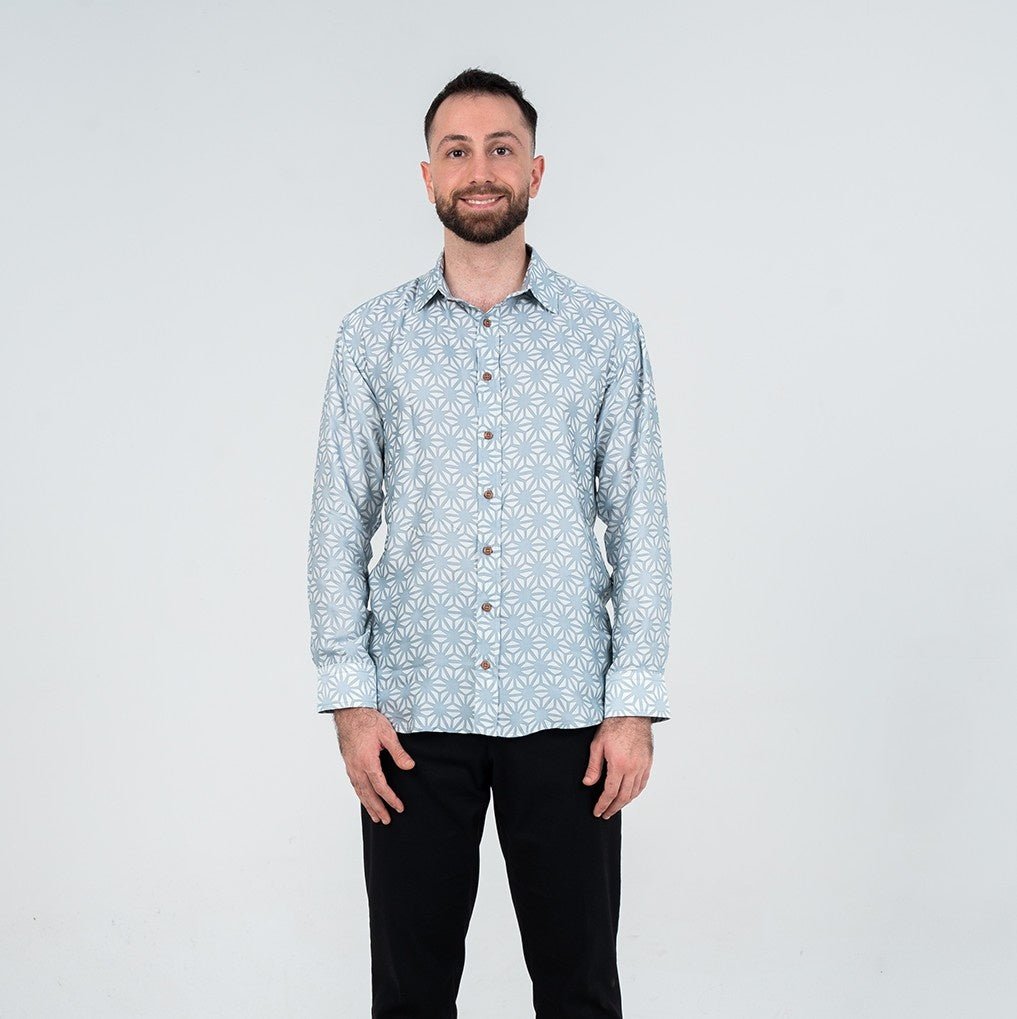 Man wearing a light blue patterned shirt against a white background