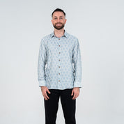 Man wearing a light blue patterned shirt against a white background