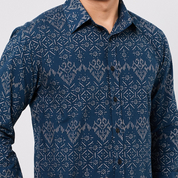 Blue patterned shirt worn by a person on a light gray background
