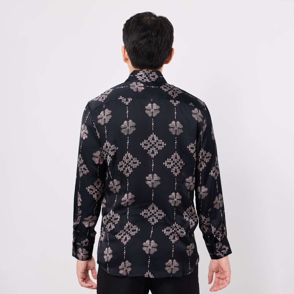 Person wearing a black patterned shirt on a white background
