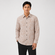 Man wearing a patterned beige shirt on a white background