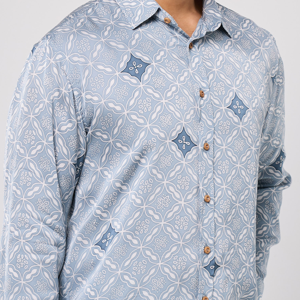 Light blue patterned shirt with brown buttons on a white background