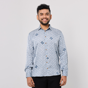 Man wearing a patterned blue shirt against a plain background