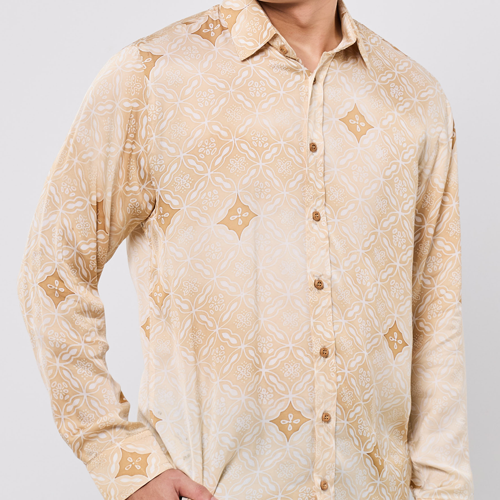 Beige patterned shirt worn by a person on a light gray background
